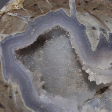 Load image into Gallery viewer, Close-up of a geode with crystal formations inside