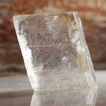 Load image into Gallery viewer, Clear crystal with natural rough surface on a blurred background