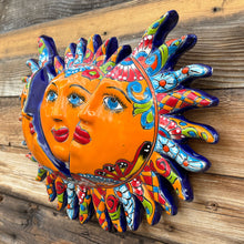 Load image into Gallery viewer, Colorful sun-shaped wall art with faces on a wooden background