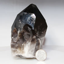 Load image into Gallery viewer, Smoky crystal with a dime for scale on a white background
