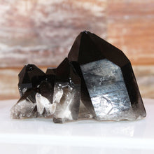 Load image into Gallery viewer, Black and clear crystal formations on a white surface with a blurred background
