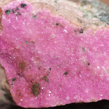Load image into Gallery viewer, Close-up of a pink crystal with embedded minerals on a blurred background
