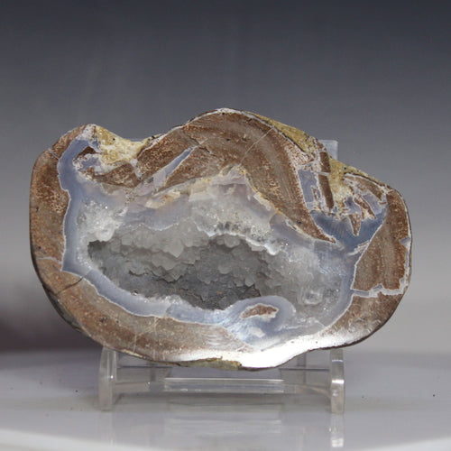 Geode crystal on a stand against a gray background