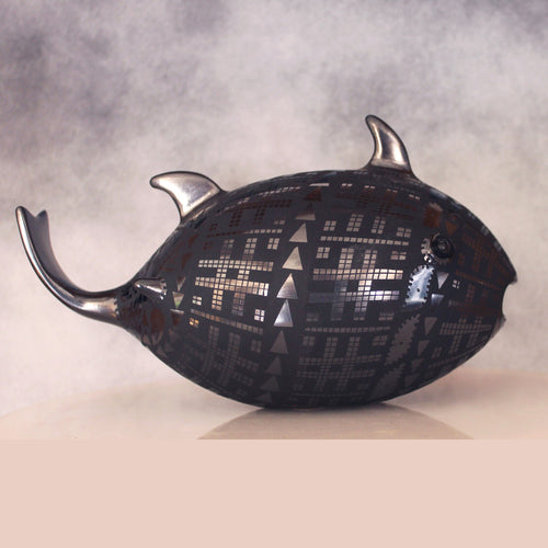 Decorative fish-shaped object with geometric pattern on a neutral background