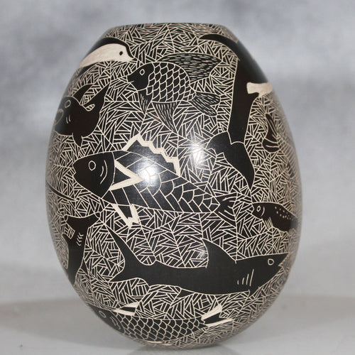 Decorative vase with black and white fish pattern on a gray background